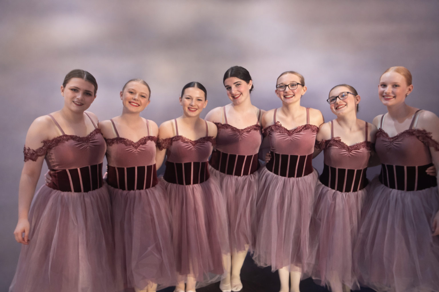 Seven ballet dancers in mauve costumes